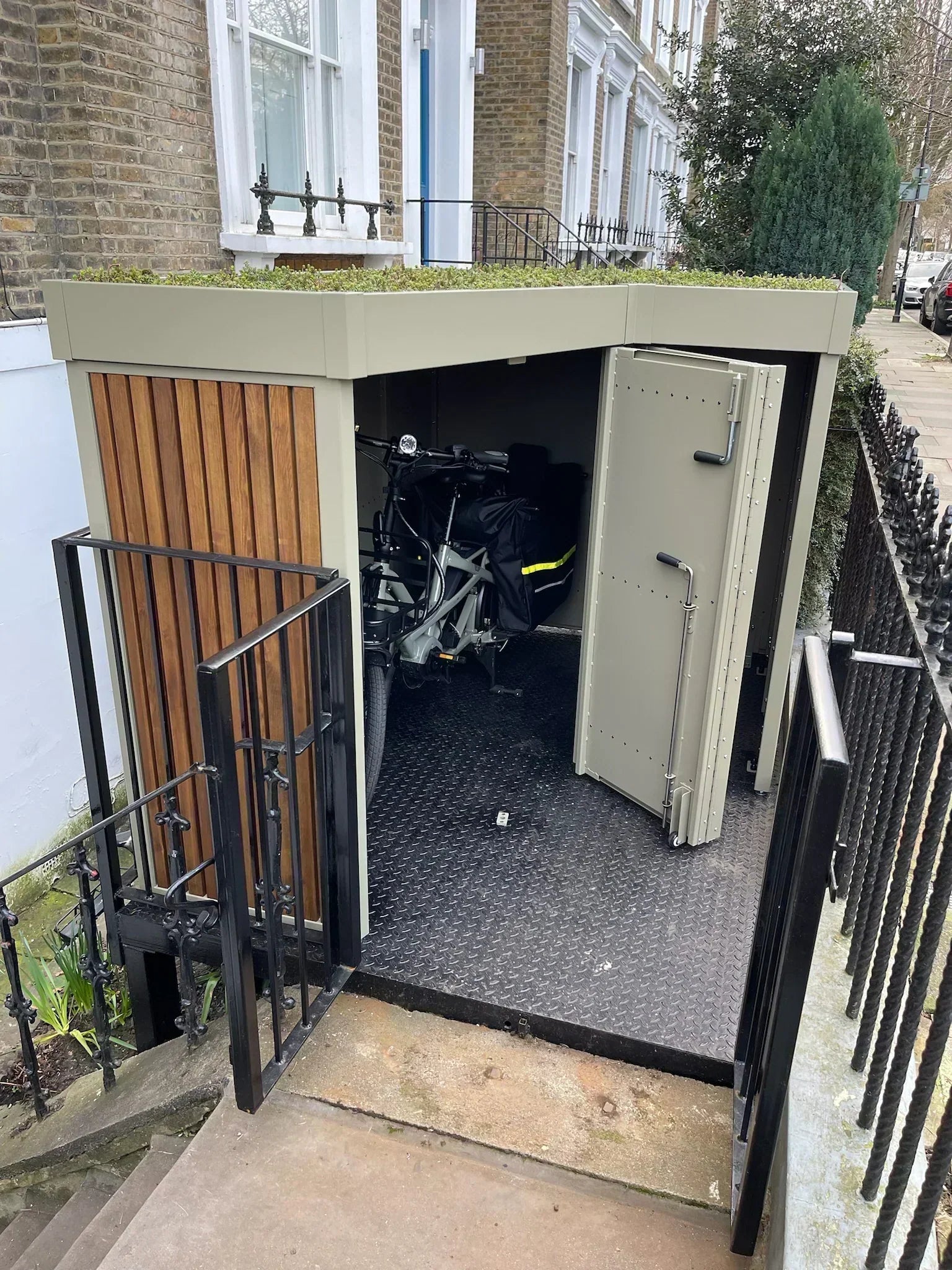 Cargo bike beige store with green roof and timber cladding, double hinged open door