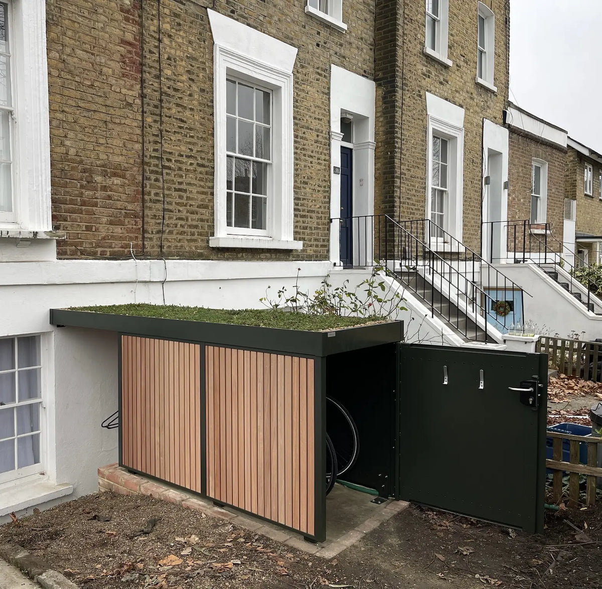 Angled view of an open bespoke Verde Uno with a side view of the vertical bike rack and extensive green roof.