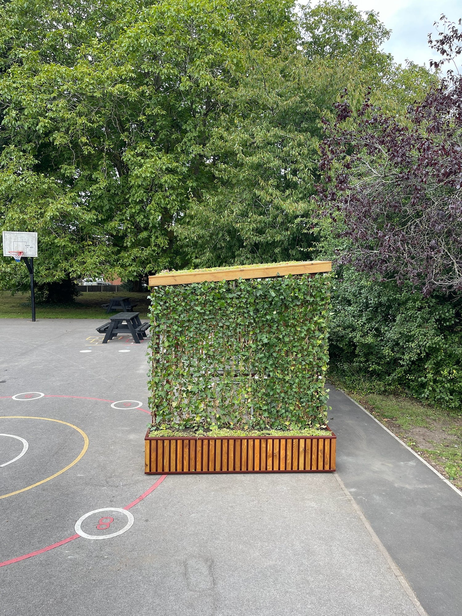 Durable bike shelter featuring a green roof and privacy screens, designed to support biodiversity and provide secure storage for community use.