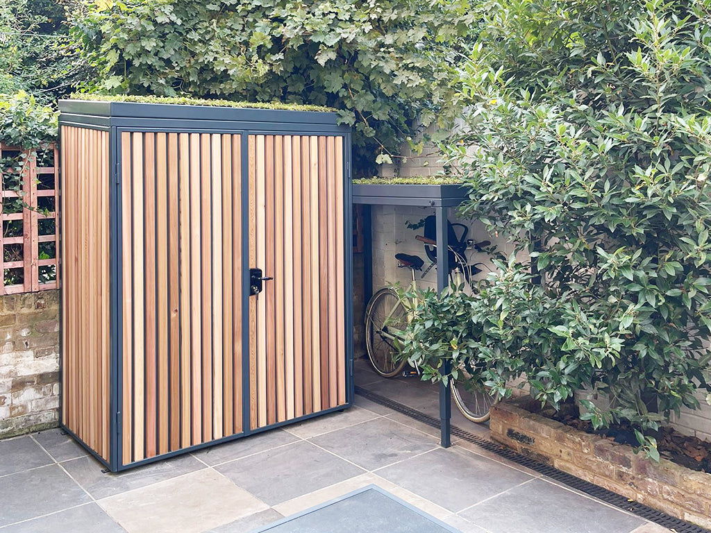 Green roof bike and garden shed designed to accommodate bicycles with child seats, showcasing spacious and functional design.