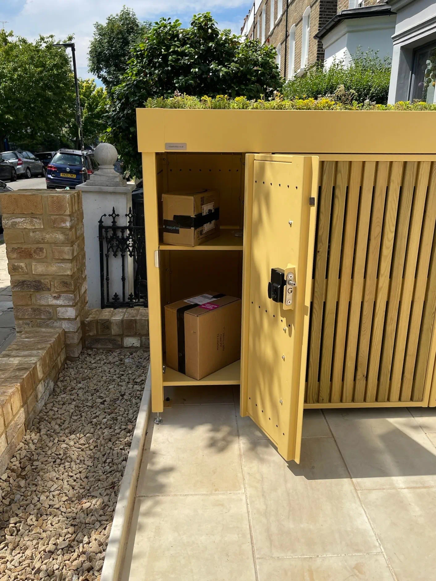 Open parcel box with combination lock in a bespoke London front garden storage unit.