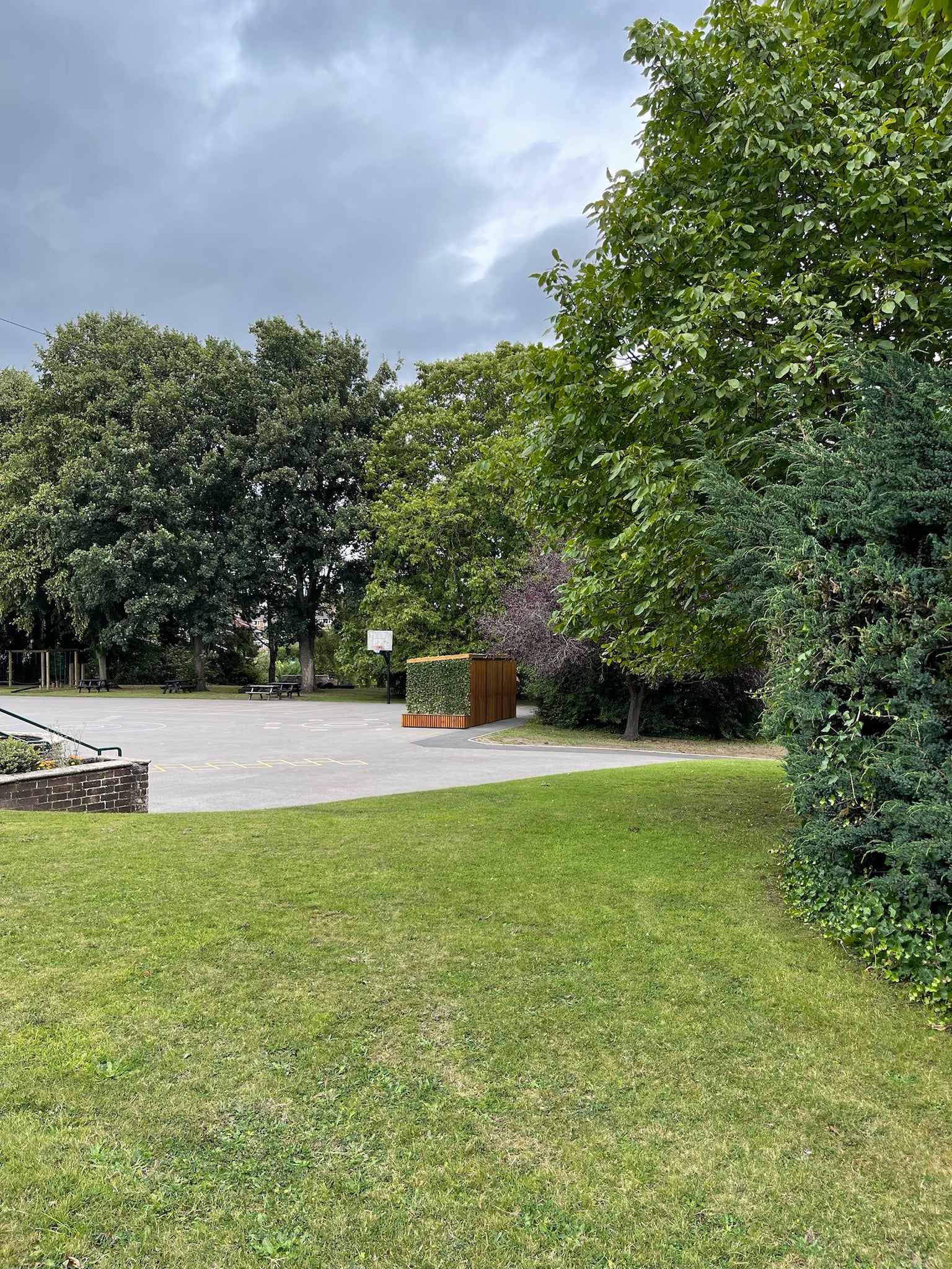 School cycle shelter featuring vertical timber cladding and a planted green roof, providing secure and sustainable storage for students' bikes.
