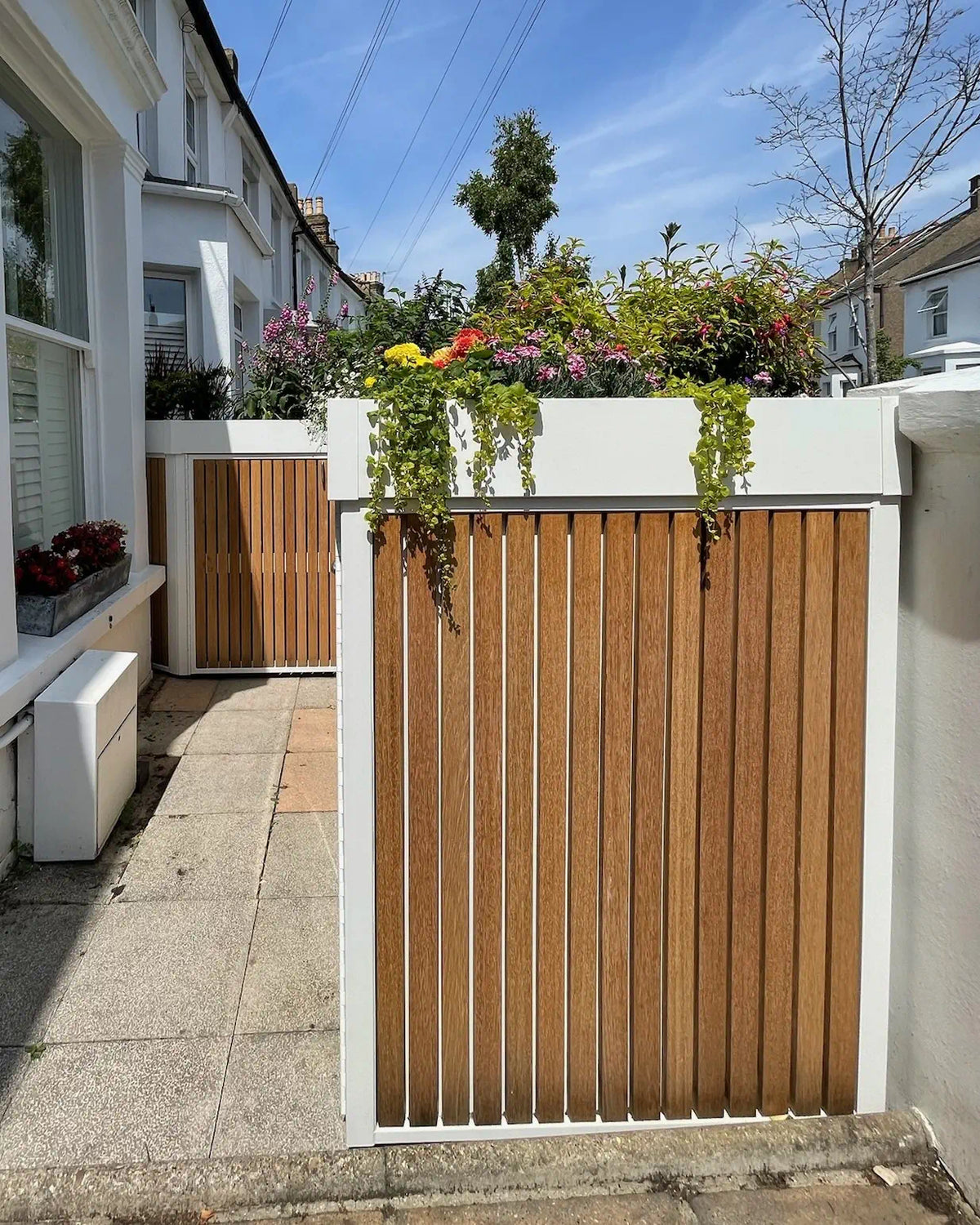 Close-up of timber cladding and the clean lines of the bespoke bike store positioned around a bay window.