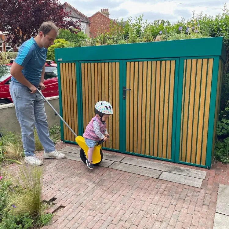 Turquoise blue standalone bike and bin store with green roof, integrated with planting and paving as part of a coherent front garden design