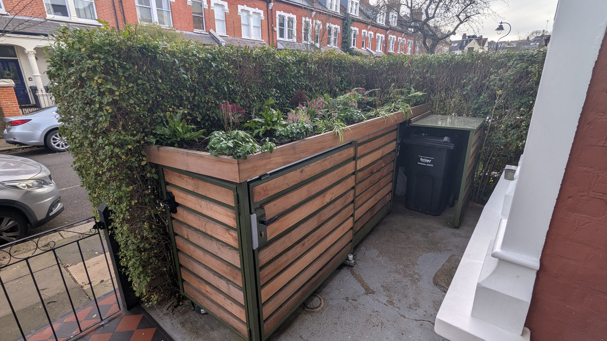 Verde Link compact bike and bin store with timber cladding, green roof, sliding door for bikes, and openable bin lid above.