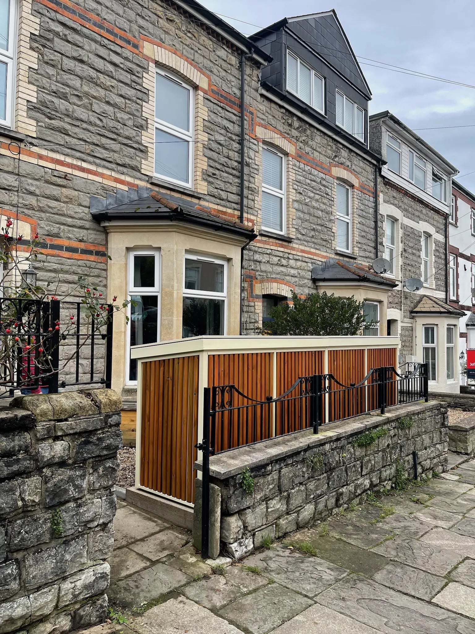 Street view of installed bespoke Verde Plus double compartment bike store with neutral colour metal frame and timber cladding