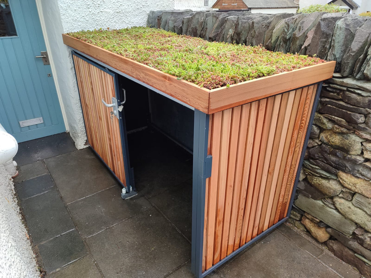 Verde Uno compact bike store with timber cladding, green roof, and sliding door open to reveal storage area.