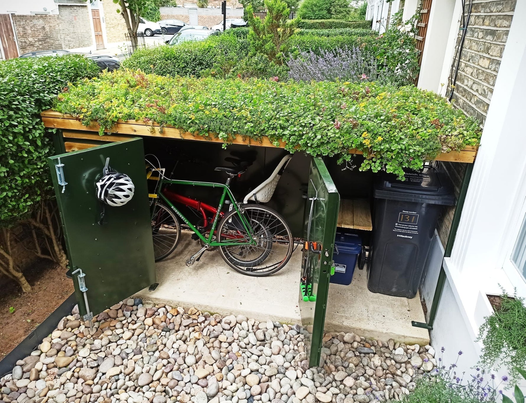 Bespoke Bikes and Bins Storage with planted Green Roof, heavy-duty steel enclosure painted green with natural timber cladding - open with bikes and bins visible