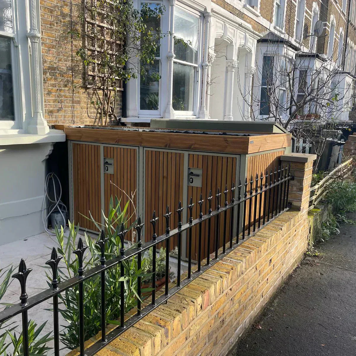 Bespoke olive grey with vertical walnut timber cladding bin and bike storage solution with green roof 