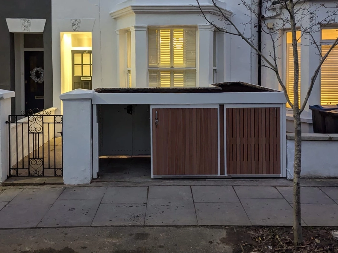 Property edge green roof bins and bike shed, tailored around bay window 