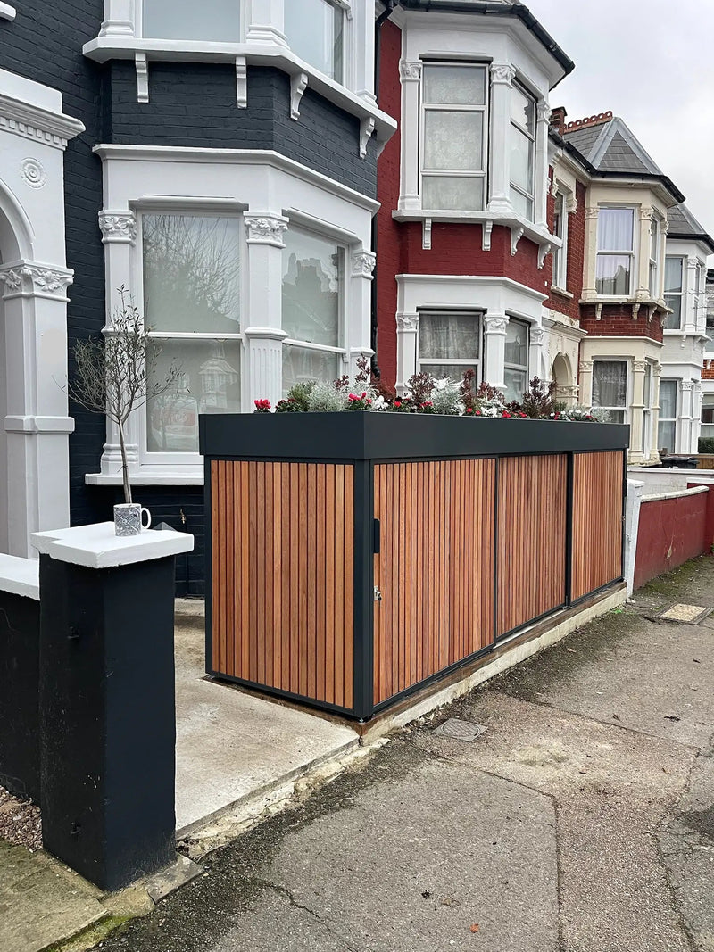 After image of slim anthracite grey bike and bin store with sliding doors and planted roof replacing the front wall in a London front garden
