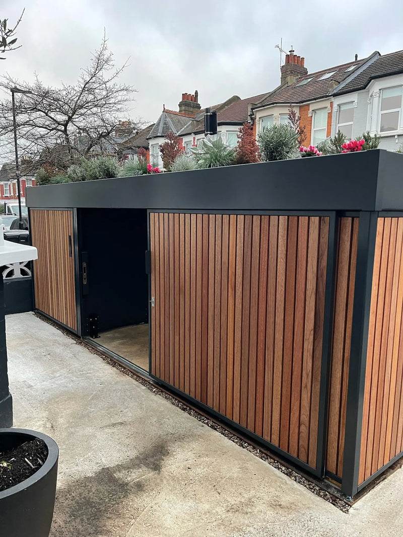 House-side view of anthracite grey bike store with sliding door open, providing direct bike access in a London front garden