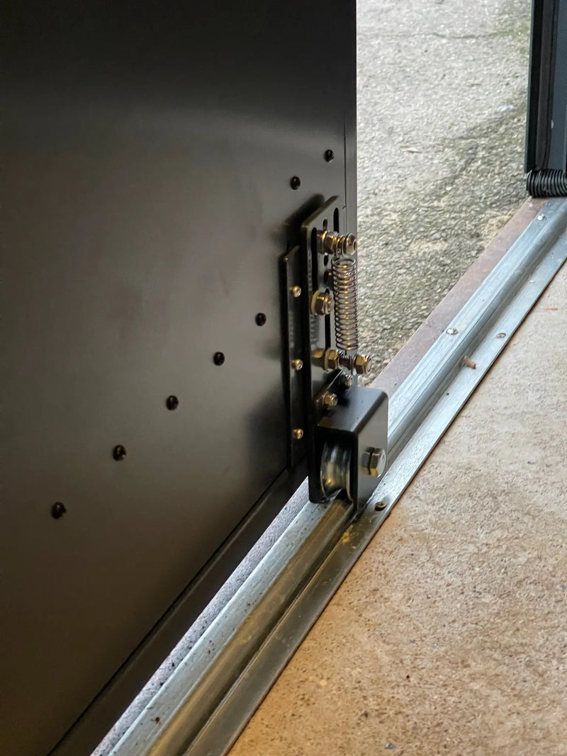 Detail of sliding door wheel mechanism on anthracite grey bike store, designed for smooth and durable daily use