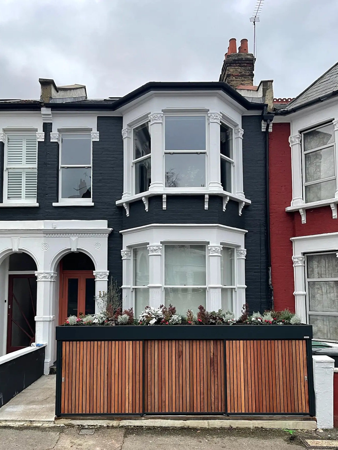 Front view of closed anthracite grey bike store with sliding doors, forming a clean modern front wall replacement
