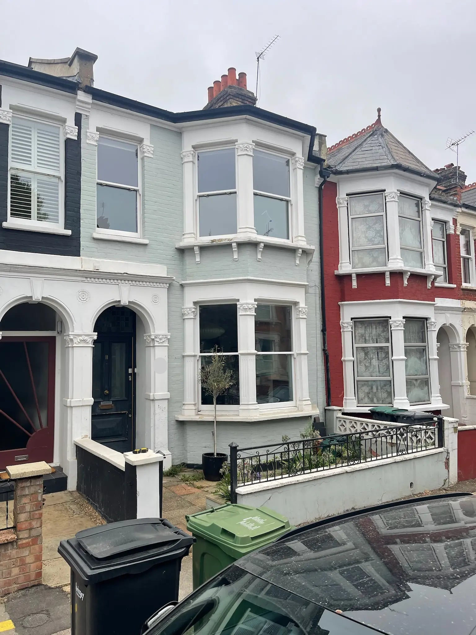 Before image of London front garden with cluttered bins and bikes, lacking integrated storage and modern boundary treatment