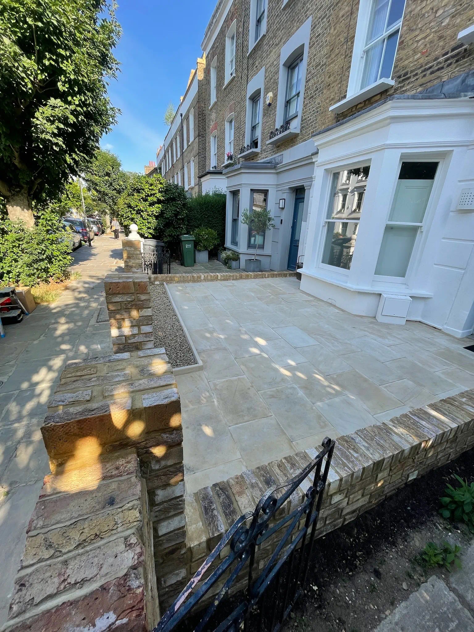 Before photo of a paved London front garden with no outdoor storage.