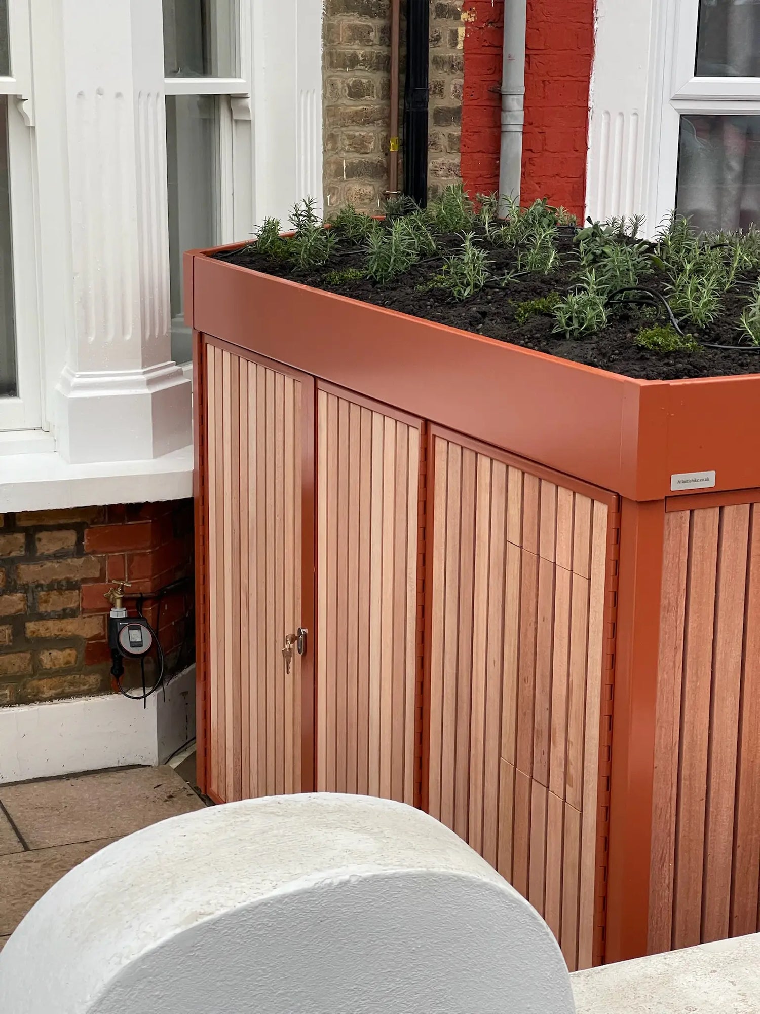 Detail of bespoke side storage in a London terraced home front garden, designed for family bike storage and parcels.