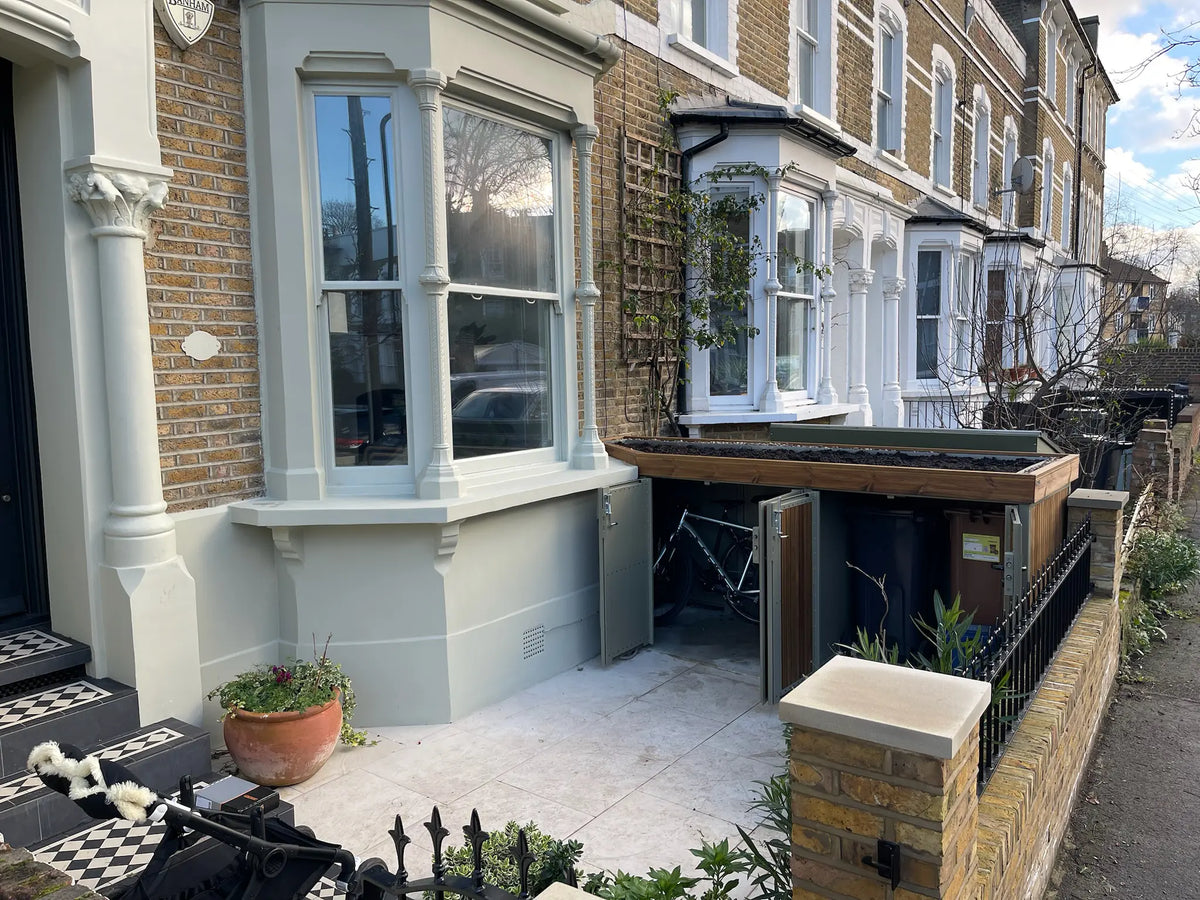 Custom bike and bin storage solution seamlessly wrapped around a bay window, maximizing front garden space.