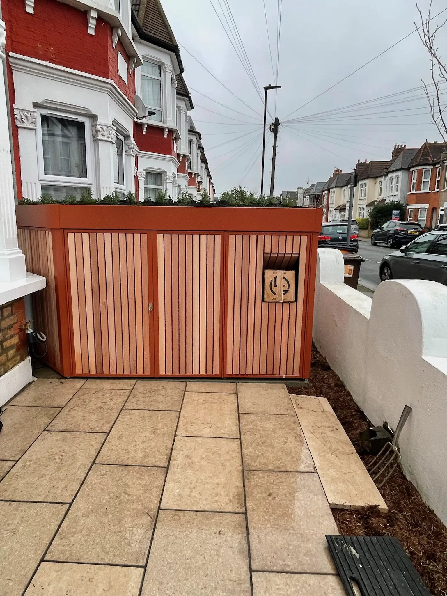Front garden bike storage with integrated parcel box, ideal for London families receiving regular deliveries.