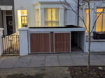 Verde Muro bike and bin store with timber cladding and green roof, sliding door open on bin storage side.