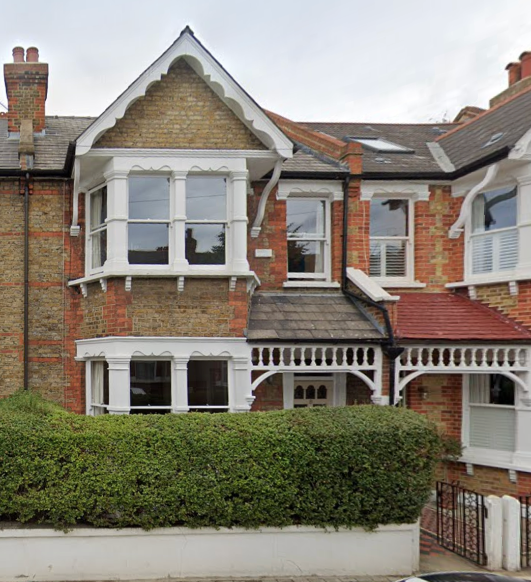 Before renovation of a terraced house front garden with low brick boundary wall and dense planting for privacy, before replacement of the front wall