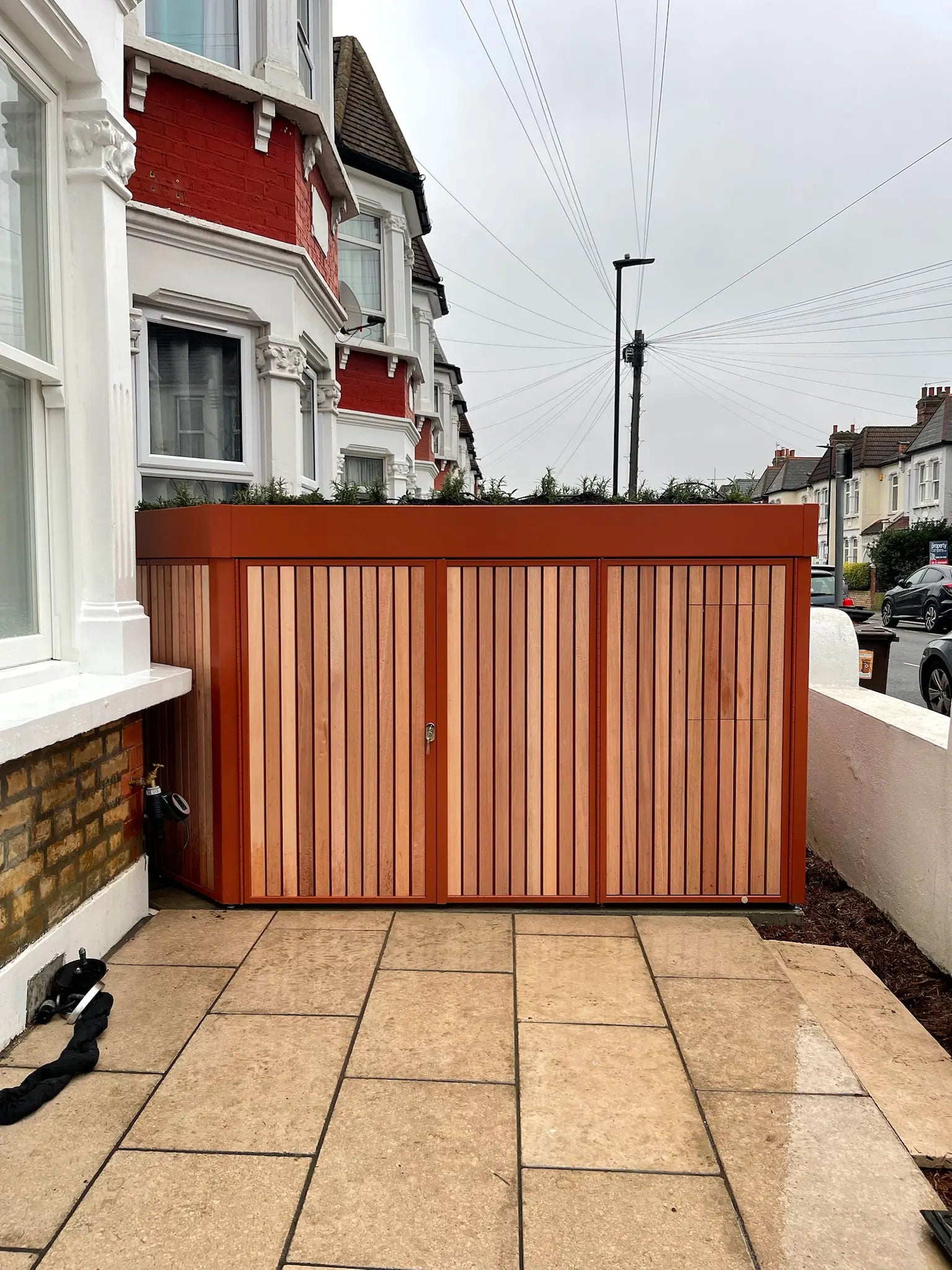 Closed front garden bike storage integrated into a London terraced property, designed for families and everyday cyclists.