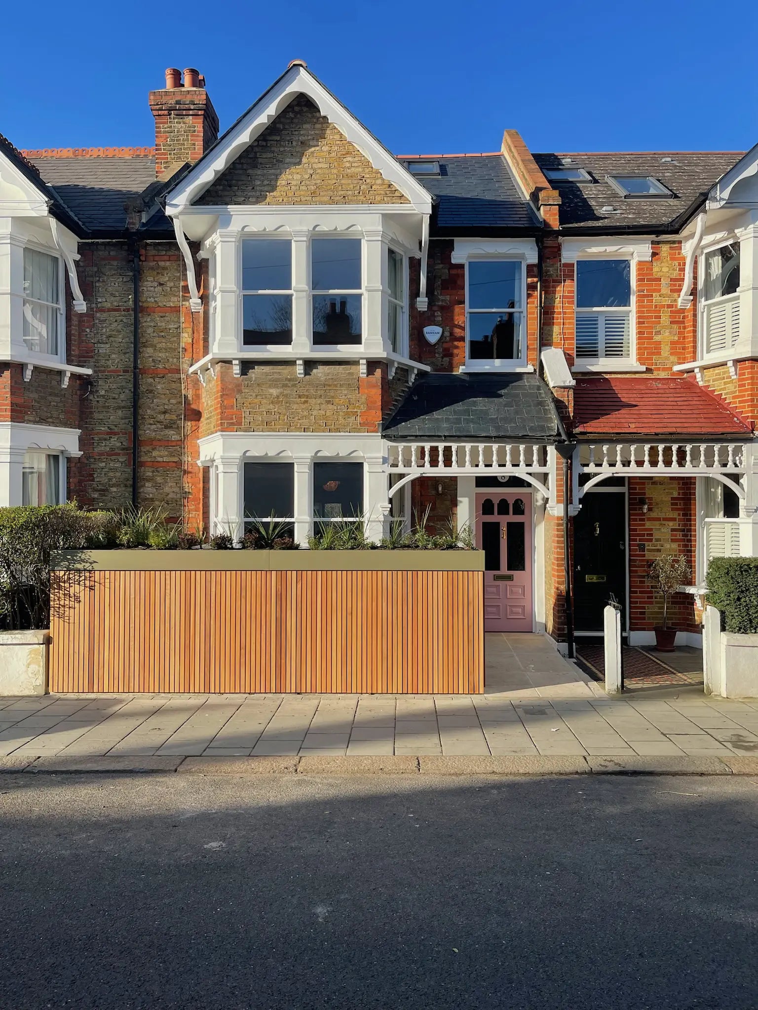 Redesigned front garden with integrated boundary storage replacing the front wall, featuring a planted green roof and clean frontage