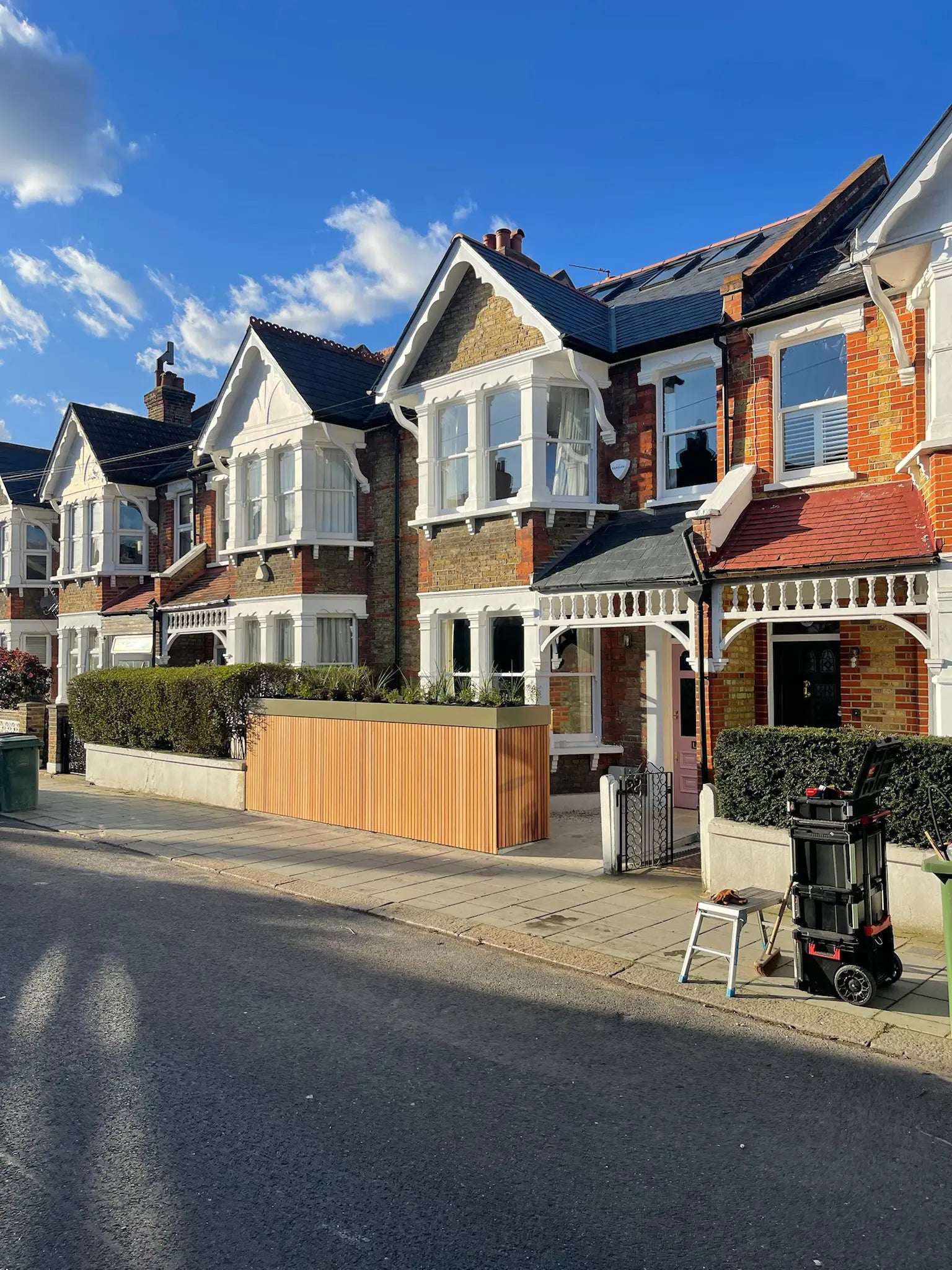 Street view from the right of redesigned front garden with storage wall and green roof boundary