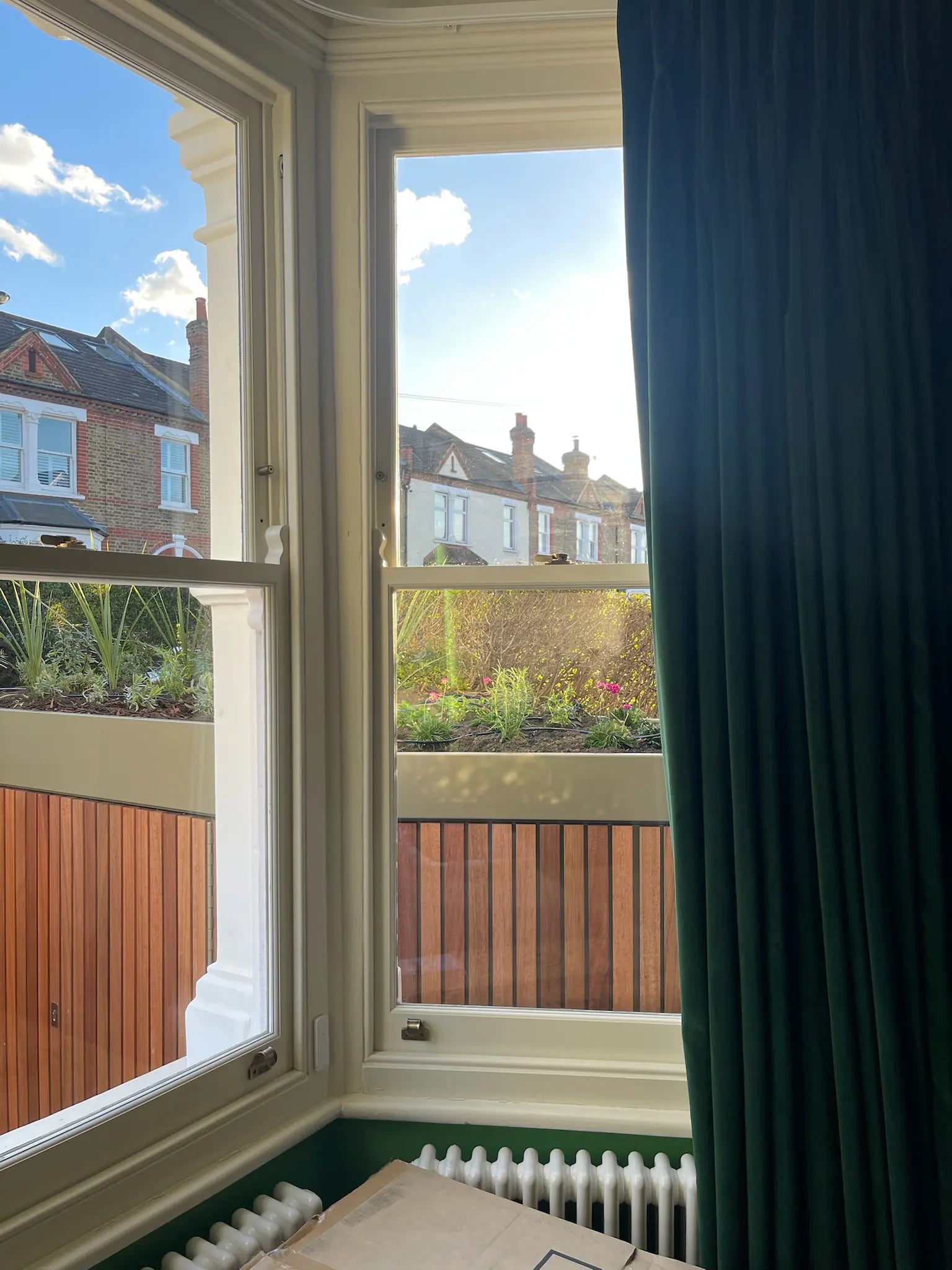 View from front room looking out onto redesigned front garden with integrated storage boundary and planting