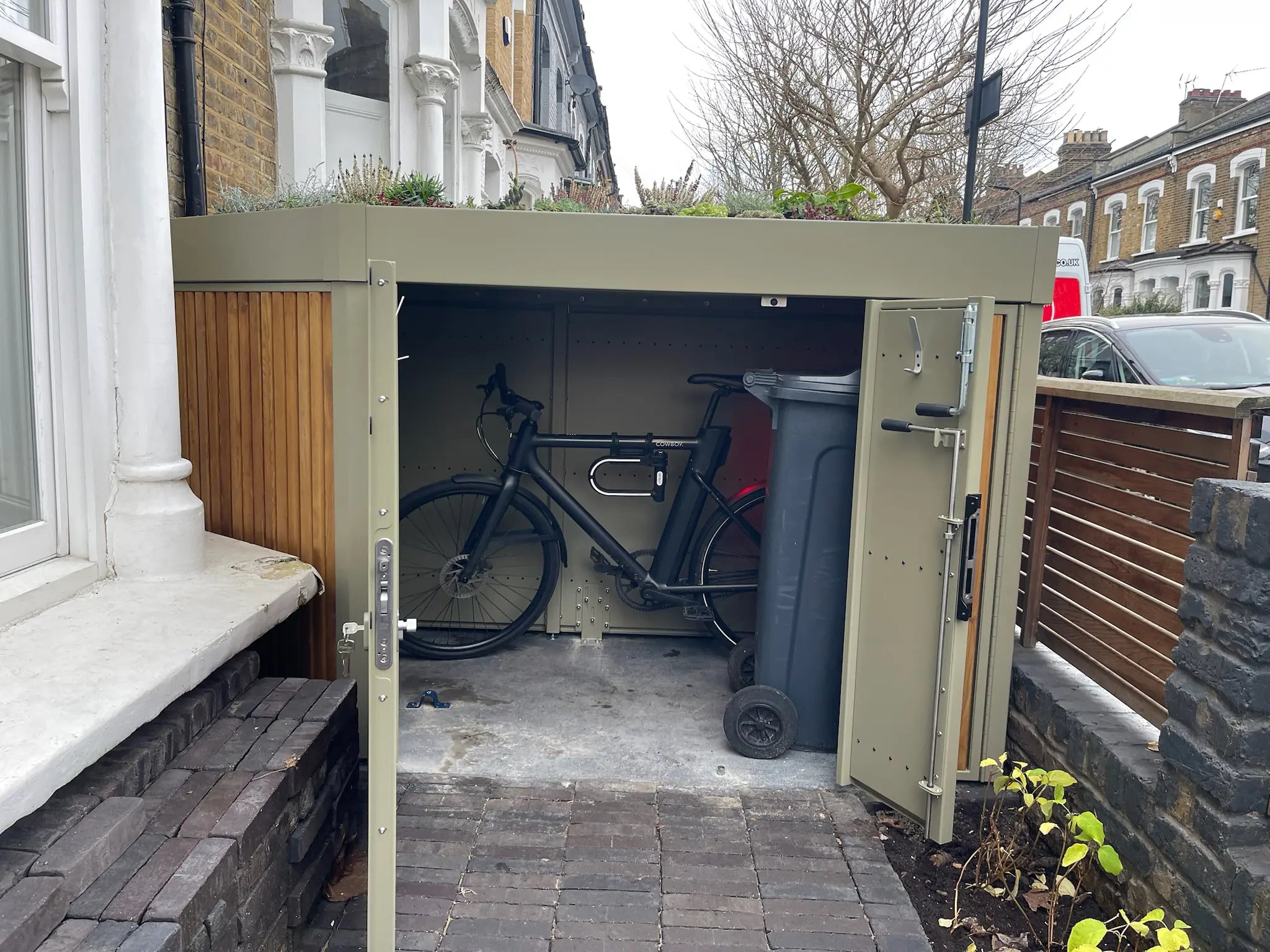 Interior of London front-garden bike store with e-bike and concealed bin storage