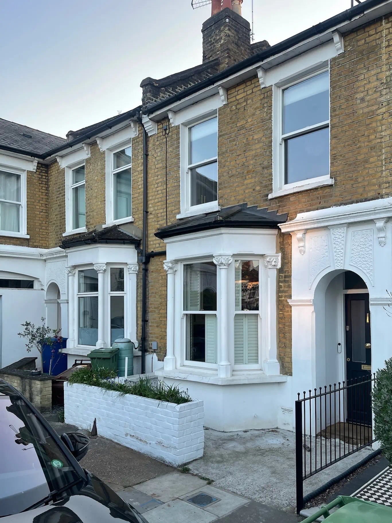 Front garden of London terraced house with low white brick wall and no usable storage space.