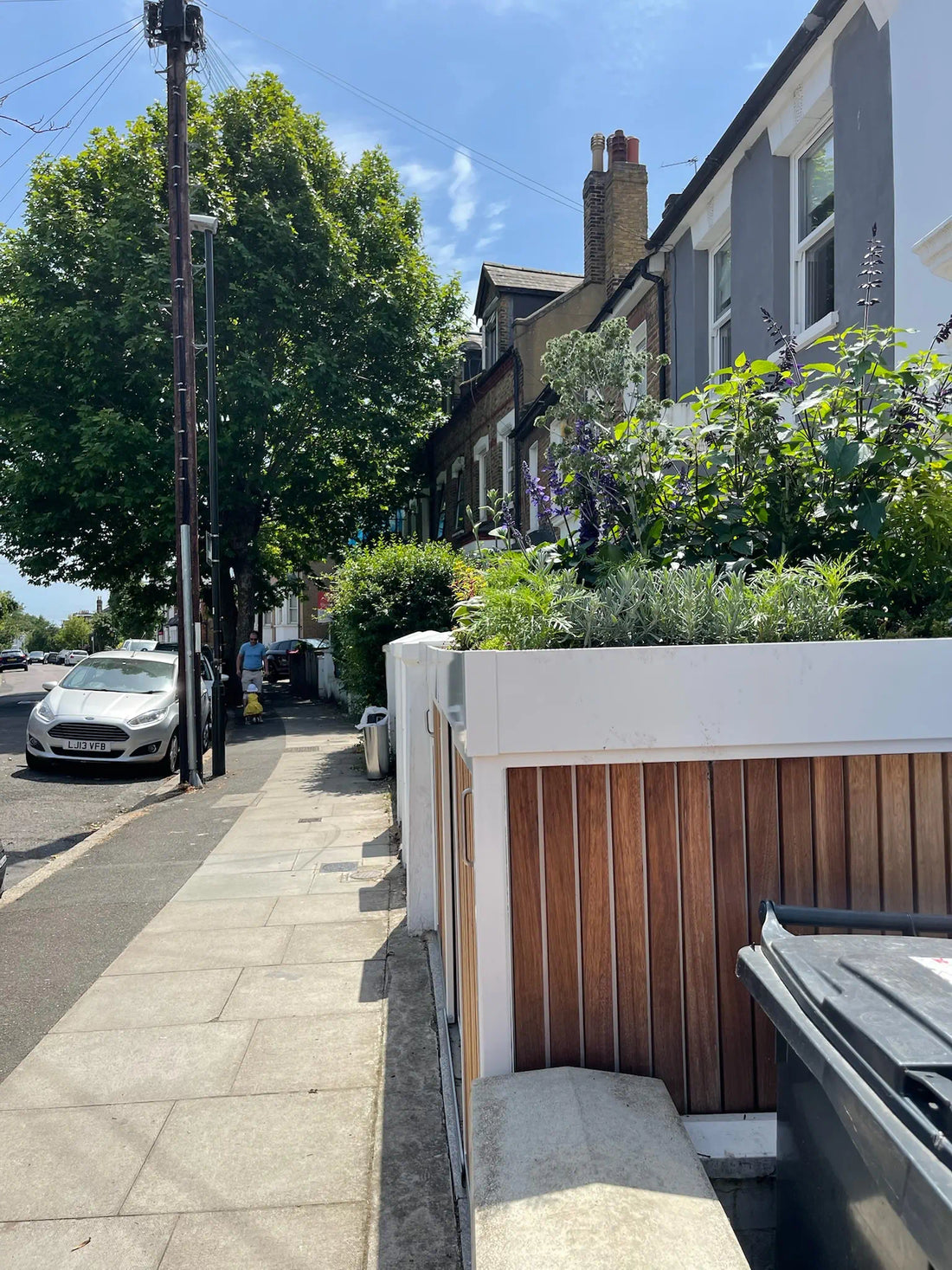 Walk past the front garden and discover a white bespoke bike and bin store with sliding doors and a fully planted green roof in bloom.