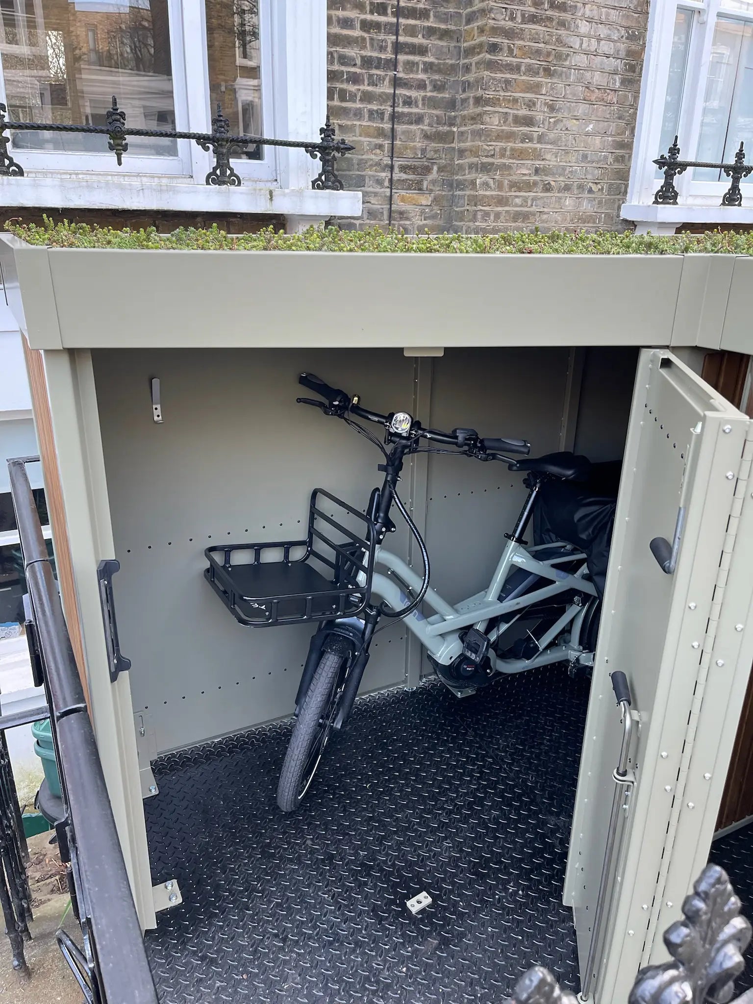 Verde cargo bike shed with both doors wide open and a cargo bike parked inside